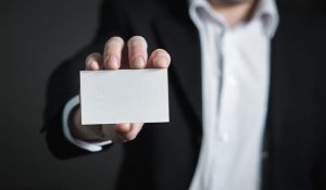 man in suit holding blank business card